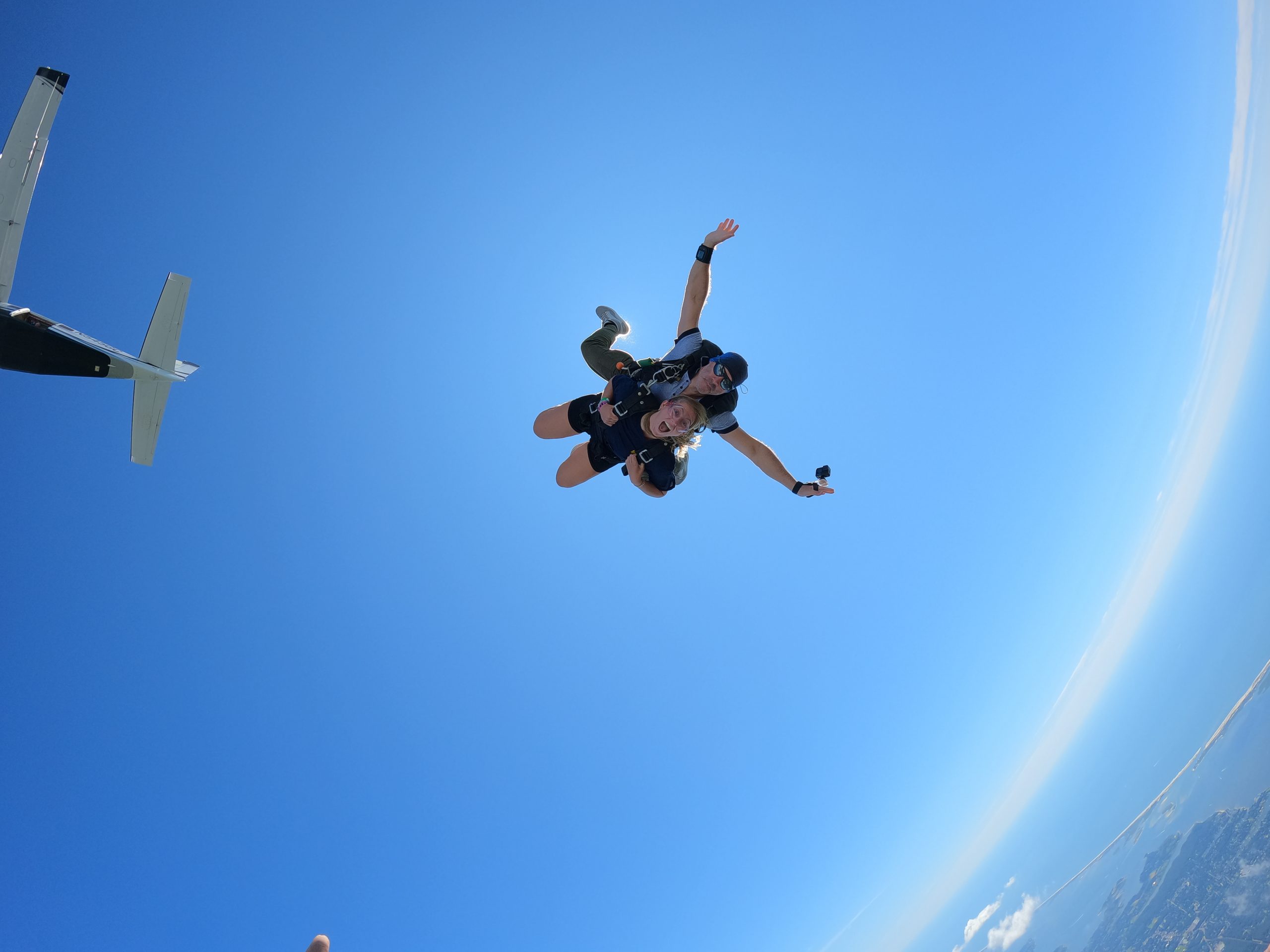 mid air skydiving shoot of instructor with female skydiver