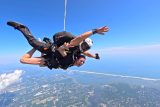 woman attached to tandem skydiving instructor freefalling over Long Island